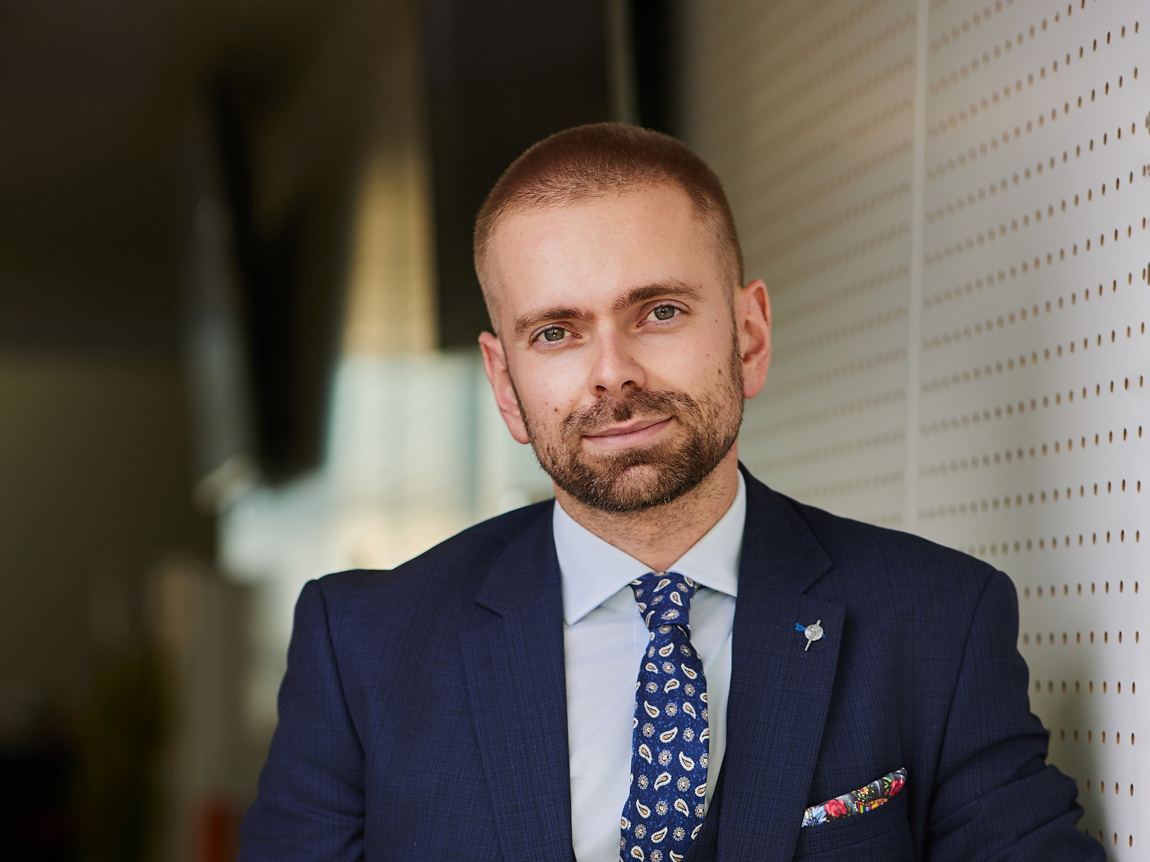 Młody mężczyzna w garniturze widziany od piersi w g&oacute;rę